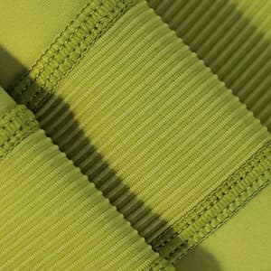 High-waisted elastic yoga leggings in a vibrant green colour, featuring ribbed texture and stitching details.