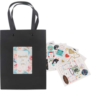 A small black vertical paper bag with knitted handles, accompanied by a selection of decorative stickers.