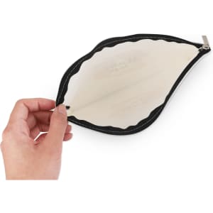 A hand holding a rectangle canvas cosmetic bag in black, featuring a clear interior and a zip closure.