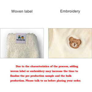 A close-up view of a woven label and embroidered design on a fabric, featuring a bear motif.