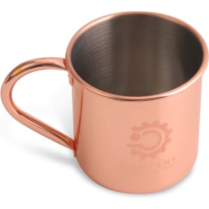 A copper Moscow Mule mug with a shiny finish and a handle, featuring a logo on the side.