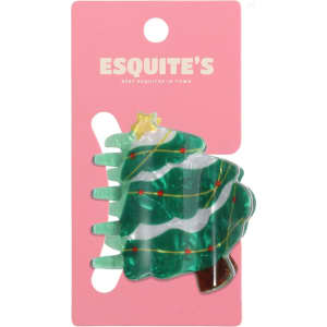 A green Christmas tree hair claw with decorations on a pink backer. Features a branding logo.