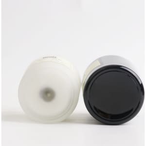 A 2.2oz glass candle in black and white, featuring a simple design and a logo on the bottom.