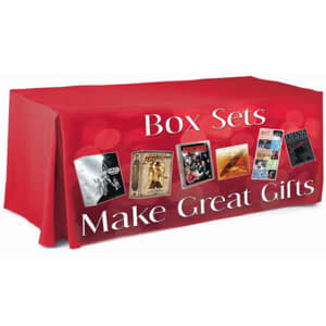 A red 6ft tablecloth with pleats and a logo, featuring images of box sets and text about gifts.