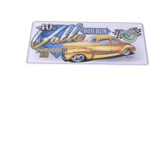 A decorative licence plate featuring a yellow classic car and illustrations, with a logo and event details.