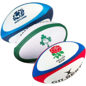 Three stress rugby balls in blue, green, and red, featuring different logos on each.