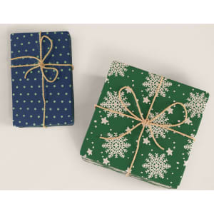 Two wrapped gifts, one in blue with polka dots and the other in green with snowflakes, both tied with twine.