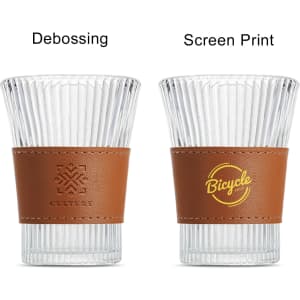A drink bottle with a clear glass body and a brown leather cup sleeve. It features a logo on one side.