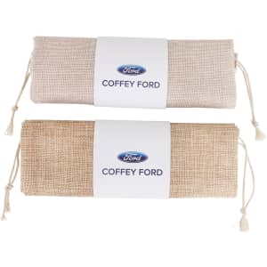 A small jute produce bag in natural and light brown colours, featuring a logo on a white label.