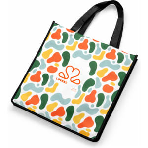 A vibrant tote bag featuring a multicoloured abstract pattern with green, orange, and yellow shapes. It has black handles and a logo.