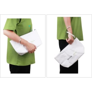A washable kraft paper cosmetic bag in white, held by a person wearing a green shirt, featuring a logo.