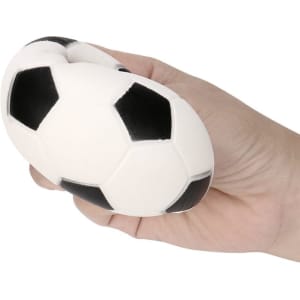 A football-shaped stress reliever in black and white, held in a hand. Features a logo.