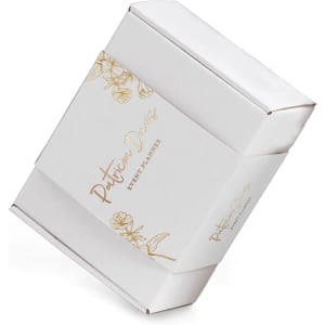 A white packaging sleeve with floral designs and a logo, designed for custom packaging solutions.