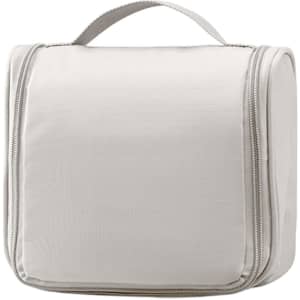 A hanging travel toiletry bag in light grey with a zip closure and a handle on top.
