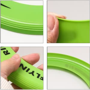 A green donut-shaped flyer with a smooth surface, held in a person's hand, featuring a logo.