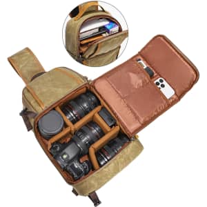 A waxed canvas camera sling bag in olive green, featuring a brown interior with compartments for camera gear and lenses.