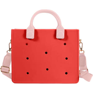 A red tote bag with pink handles and a removable shoulder strap, featuring decorative holes and a logo.
