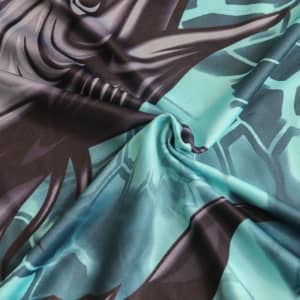 A close-up of patterned fabric featuring shades of turquoise and black, showcasing a graphic design on soft material.