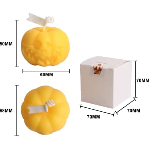 Pumpkin-shaped candles in vibrant yellow, featuring a carved face, packaged in a small white box.