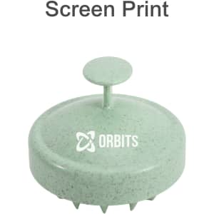 A green hair scalp massager with a round design and a centre handle, featuring a logo on the front.