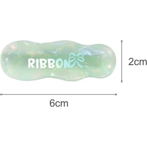 A ripple iridescent alligator hair clip in green and clear colours, featuring a logo in white. Dimensions are 6cm x 2cm.