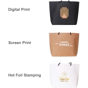 Three paper bags displayed: a black bag with a logo, a brown bag with white text, and a white bag featuring gold foil detail.