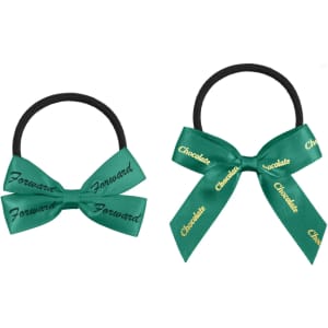 Two elastic hair bows in green with black hair ties, featuring decorative bows. One bow includes text.