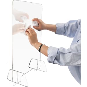 A clear personal protection screen held up with a hand wiping it clean, featuring a simple stand.