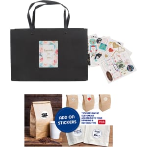 A black paper bag with knitted handles, accompanied by decorative stickers and a sample coffee bag.