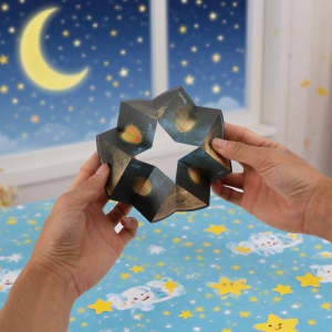 A hands-on 3D Flips Puzzle Disc in dark colours features an intricate star-like design against a starry background.