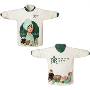 A wearable blanket featuring a spa-themed design in white and green, with a logo and illustrated character.
