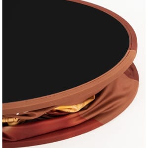 A round display counter with a black top and a fabric cover in shades of brown and gold, featuring a logo.