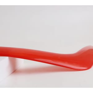A V-shaped red boomerang toy resting on a white surface, showcasing its glossy finish.