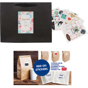 A large black paper bag with a fabric flat handle, featuring assorted stickers and design elements.