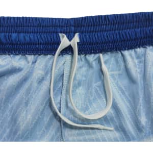 Light blue soccer shorts with a blue waistband and a white drawstring, featuring a textured pattern and a logo.
