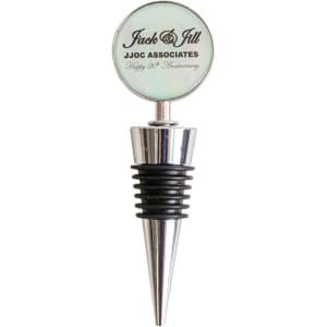 A wine stopper with a silver metal base, a black rubber grip, and a round glass top featuring a logo.