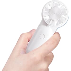 A mini portable handheld fan in white, held in a hand, featuring a circular fan design and a button.