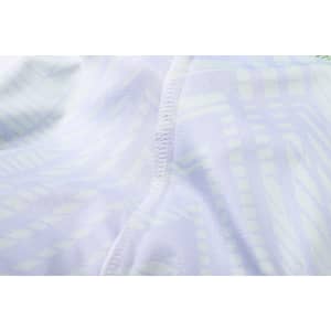 A close-up of a light-coloured, patterned fabric showcasing stitching details of a V-neck shirt.