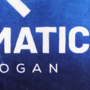 A close-up of a soft, blue flannel mat featuring a logo in white.