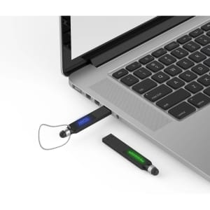 A black stylus backlit logo flash drive plugged into a laptop, with a second flash drive nearby.