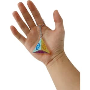 A hand holds a multicoloured puzzle pyramid keyring, featuring a shiny, geometric design.