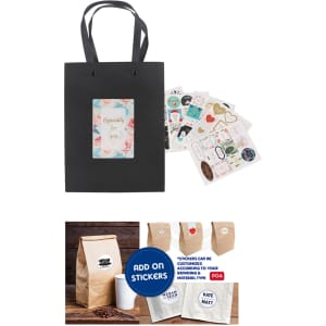 A small black vertical paper bag with knitted handles and a decorative tag, accompanied by various stickers.