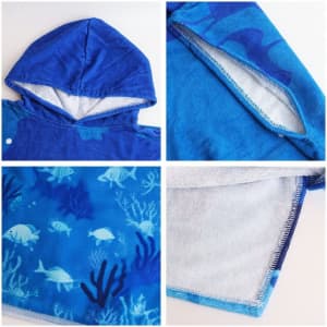 A blue cotton surf poncho towel with a hood and dolphin patterns, featuring a soft interior and no pockets.