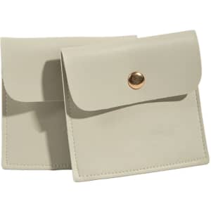A square, light grey PU leather jewelry pouch with a gold button closure. Features branding on the surface.