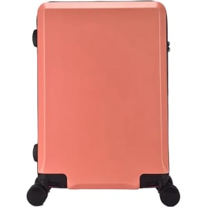 A peach-coloured wheeled suitcase with a sleek design and logo on the front.