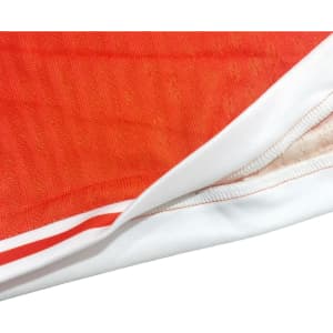 A pair of breathable sport shorts in vibrant orange with white trim and a logo.