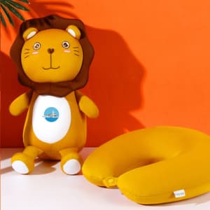 A lion-shaped travel pillow in vibrant yellow, with a plush toy design featuring a smiling face and a logo.