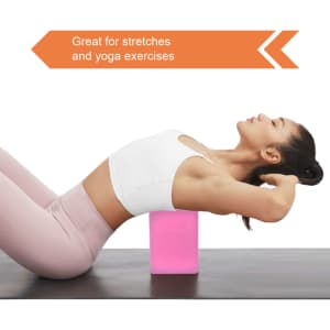 A pink EVA yoga block placed on a mat, used for stretching and yoga exercises. A person performs a pose with it.