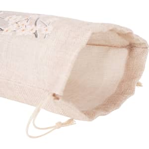 A small jute produce bag in a light tan colour with delicate embroidery, featuring a drawstring closure.