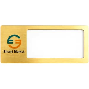 A rectangular reusable metal name badge in gold with a window for a name and a logo in the corner.